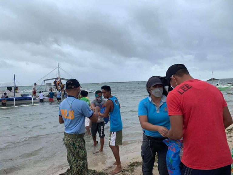 RAFI, residents, and local law enforcement work together to help unload relief packs to the island