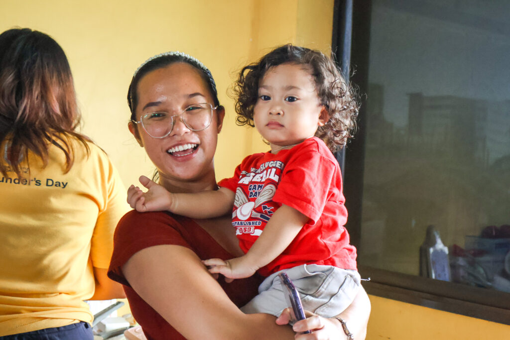 Woman smiling while holding a child